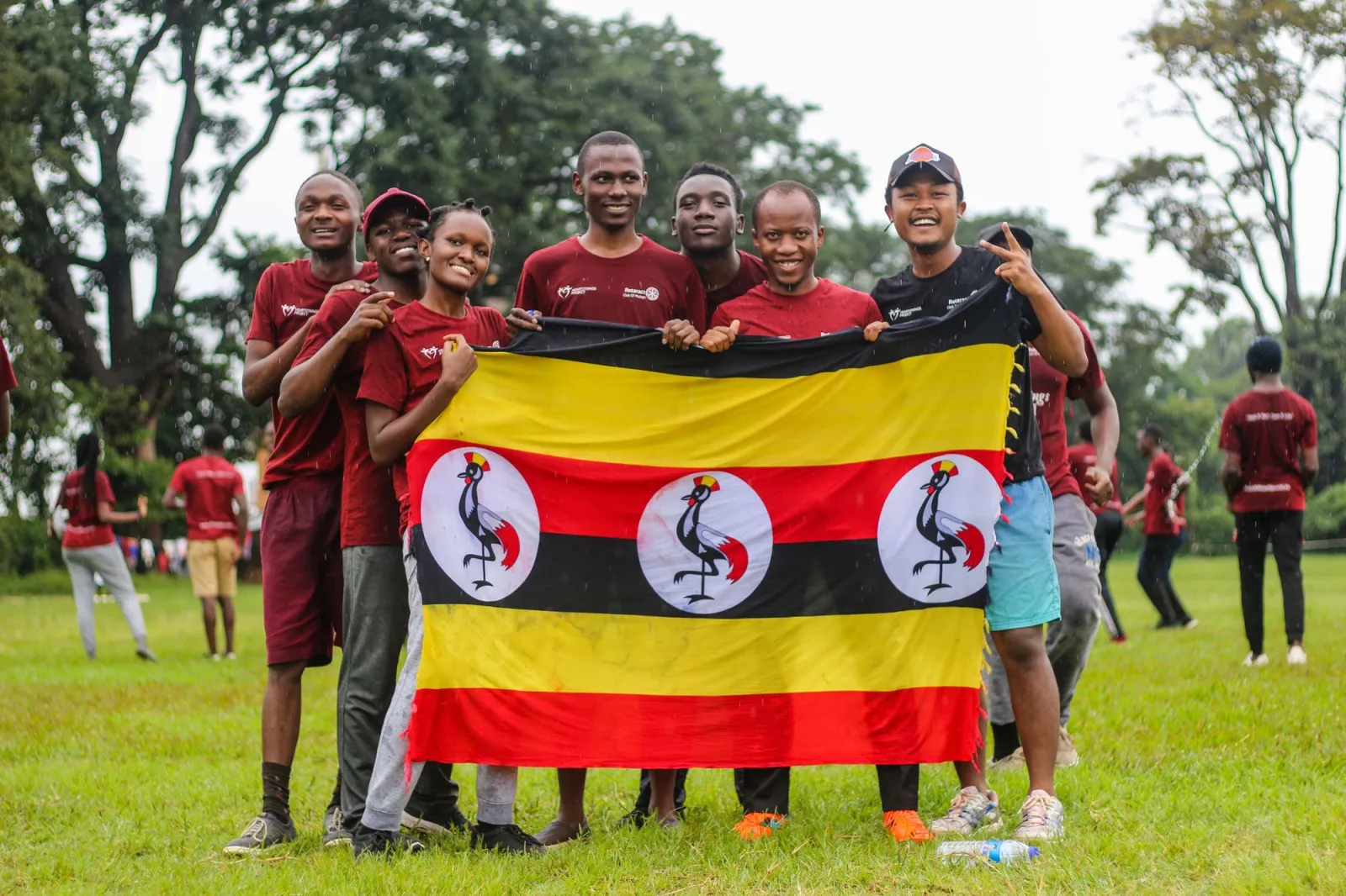 Young people holding the flag of Uganda